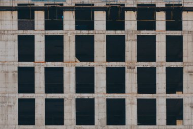 Beton ve metalden yapılmış çok katlı bir binanın çok katlı yeni bir bina inşaatı. İnşaat devam ediyor. Soyut mimari parçası 
