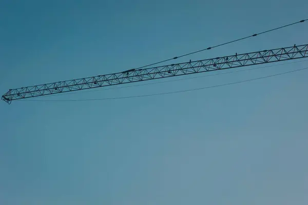 stock image Construction Tower Crane Against a blue Sky. construction crane on top of the building under construction site in day time with blue sky background