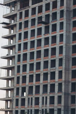 Beton panellerden yapılmış modern bir binanın ön cephelerinin yapımı, yakın plan. Bir sürü yeni kat. Endüstriyel iskelesi olan bir apartman inşaatı