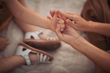 Anne çocuğuyla el ele tutuşuyor. Ebeveynler küçük bir kızın elleriyle oynuyorlar, psikolojik yardım alıyorlar. Farklı nesiller aile sırlarını paylaşıyor ya da barış yapıyor..