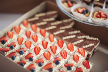 Kutuda tatil kekleri, tatlı süslemeleri. Kutudaki malzemeler, yemek hazırlama, yemek konsepti. Yemek servisi için karton kutuda tatlı teslimatı. Parti için tatlı tatlılar.