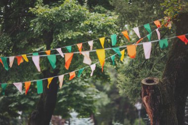 Köylerin popüler festivallerinin geleneksel dekorasyon manzarası arka plan olarak bulanık. Bir doğa arka planında renkli asılmış bayraklar
