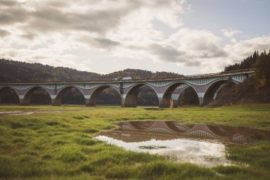 Romanya 'nın kırsal kesiminde viyadük. Eski beton köprü. Piatra Teiului kireç taşı, Romanya 'daki Bicaz Gölü' nün bulunduğu bir dağ vadisinde viyadük ve nehir manzarası