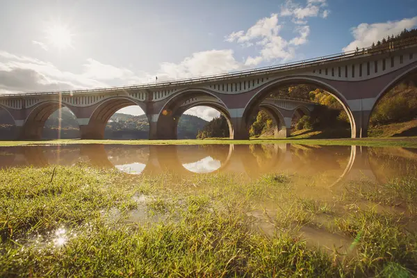 stock image Viaduct in countryside of Romania. Old concrete bridge. View at viaduct and river on a mountain valley with Piatra Teiului lime stone, Bicaz Lake in Romania