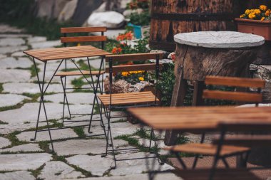 Köy tarzında kafeler ve masalar. Kahve dükkanı. Tahta sandalyeler müşterileri bekliyor, Chianale, İtalya. Alplerdeki güzel teras restoranı