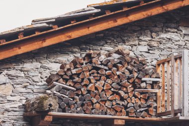 Pontechianle, Italy. Wooden logs stacked on the wall of a mountain house. Mountain Wood clipart