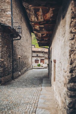 İtalya 'da taş mimari özellikleri olan küçük bir kasabanın içinden geçen bir patika. Chianale, Val Varaita, Cuneo vilayeti, İtalya 