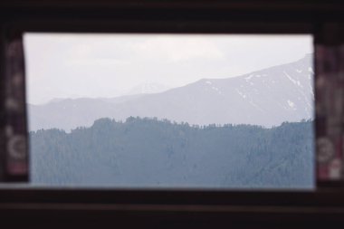 View from the window. A cloudy, mountain sunrise viewed through a window in Pontechianale, Italy during spring. clipart