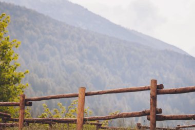 Dağ sırtında ahşap çadır. Eski çitleri yakından çek. Kahverengi ahşap çit. Tahta geçit ve gökyüzü ile Dağ 