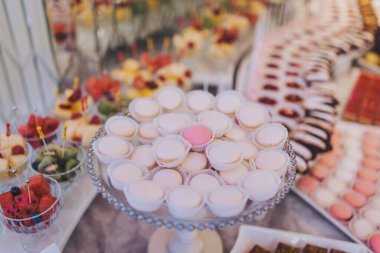 Pembe renkte yapılan bayramda çikolata. Ön planda yemek standında lezzetli bir badem kurabiyesi var. Açık büfede farklı şekillerde pişmiş şekerler.. 