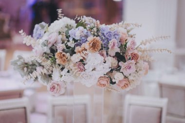 Güzel çiçek açan çiçekler (güller, ortancalar, karanfiller, östoma) mavi, antika mavi ve şeftali rengi düğünlerde. 