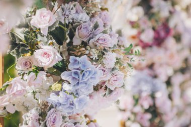 Düğün çiçeği arka planı, taze gül, bir demet çiçek. Bahçe partisi için güllerle çiçek aranjmanı. Dışarıda güzel bir düğün töreni düzenlendi..