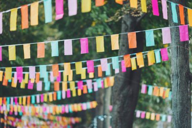 Parti bayrakları bir partide süslenmişti. Bir şehir tatili geçmişi. Yaz parkında renkli mini bayraklar. Doğum günü partisi için dekorasyon. Popüler festivallerin geleneksel dekorasyonu, etkinlikler
