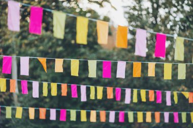 Parti bayrakları bir partide süslenmişti. Bir şehir tatili geçmişi. Yaz parkında renkli mini bayraklar. Doğum günü partisi için dekorasyon. Popüler festivallerin geleneksel dekorasyonu, etkinlikler