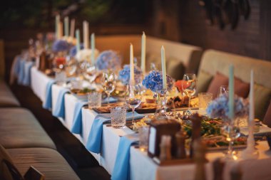 Düğün süslerinde çiçekler var. Düğün partisi için süs mumları. Mavi ortanca. Çiçek masalarıyla muhteşem bir düğün masası dekorasyonu.. 