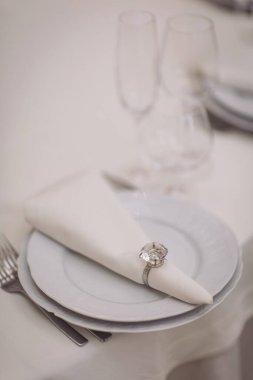 Şölen masasında peçeteler, bardaklar ve çatal bıçaklar var. Restoranda boş tabaklar ve bardaklarla dolu şenlik masası.