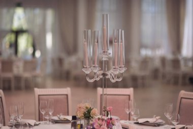 Düğün töreninde, yemek masası sayısız uzun ve ince mumlarla süslenir, sıcak ve romantik bir ortam yaratır.