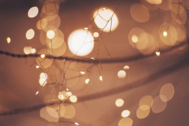 Odakları çözülmüş güzel Noel ışıkları. Yeni yıl çelenkleri ve fenerleri tek bir tele tutunup, yumuşak, sıcak bir ışıkla parlıyor ve yeni yıl arifesi atmosferi yaratıyor.