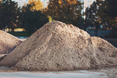 Farklı parçalardan parçalanmış bir taş. Pürüzsüz yüzeyi olan gri çakıl yığınının yakın çekimi. İnşaat alanının yakınında çok fazla kum var.