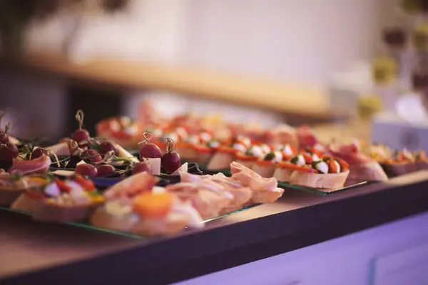 Tatil için atıştırmalıklar, yemek servisi. Çeşitli hafif atıştırmalıklar. Yemek tabağı. Büfe masasında bir sürü sandviç var. Et, balık, fındık, peynir, önemli olayın sebze kanepeleri