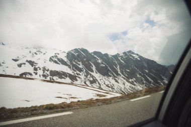 Bir arabanın penceresinden, karlı zirvesi olan, harika bir dağ manzarası.. 