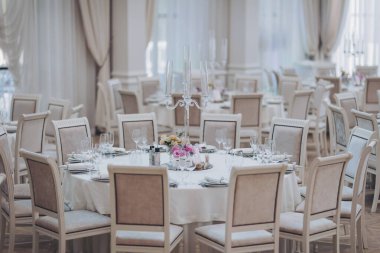 Güzel çiçek ve düğün masalarının mum süslemesi. Ziyafet masası ve dekorasyon. Masada çatal bıçak takımı var. Etkinlik partisi için masalar hazır. Lüks, zarif bir masa, bir restoranda yemek hazırlıyor.