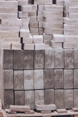 Düzgünce dizilmiş beton tuğlalar, yaklaşan inşaat projeleri için hammaddeleri sergiliyor. Güneş ışığı onların dokularını ve renklerini vurgular