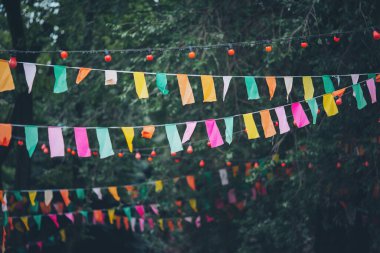 Parlak renklerde canlı bayraklar ve ağaçlar arasında şakacı fenerler asılıdır. Bu da öğleden sonra bir açık hava olayı için şenlikli bir atmosfer yaratır.