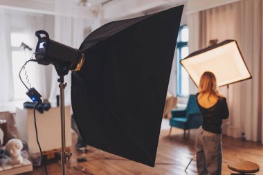 Bir oturum sırasında sanatsal ifade ile ilişkili bir modelle ışık ayarlarını vurgulayan yaratıcı bir iç mekan fotoshoot.