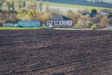 Tarlalar, kırsal kesimlerin cazibesi ve dingin güzellikleriyle dolu güneşli bir günde kırsal kesimde, tuhaf bir evin yanında ekilmeye hazır.