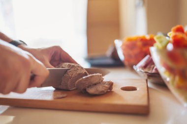 Canlı bir mutfak hazırlığı sırasında taze kesilmiş et ve canlı sebzeler ahşap bir kesme tahtasının üzerinde sergilendi.