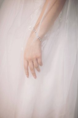  Baharda açık havada yapılan bir düğün kutlamasında sakin, doğal bir ışıkta çekilen gelinlik zarafetinin karmaşık detayları.