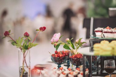 Gösterişli bir kutlama sırasında zarif bir yemek ortamında renkli tatlılar ve taze meyveler içeren enfes bir tatlı tabağı.