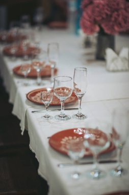 Canlı pembe çiçekleri ve titizlikle düzenlenmiş sofra takımlarını içeren zarif yemek düzeni özel bir toplantı için davetkar bir ortam yaratıyor.