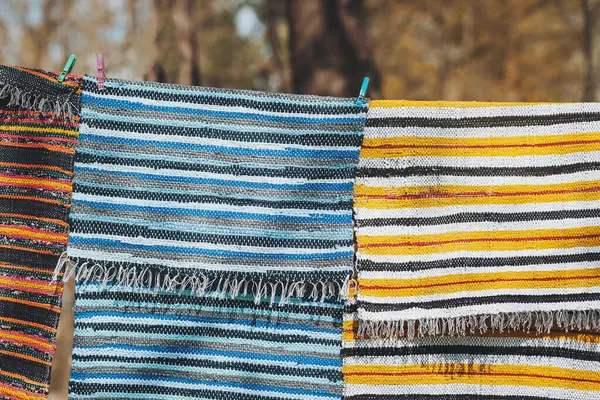 Geri dönüştürülmüş tekstil halı desenleri parlak renkli çizgiler dokuyor, nostalji ve sanatsal duyguları çağrıştırıyor. Dokuma dokular uzak diyarlar ve canlı sanatlar hakkında hikayeler anlatır.