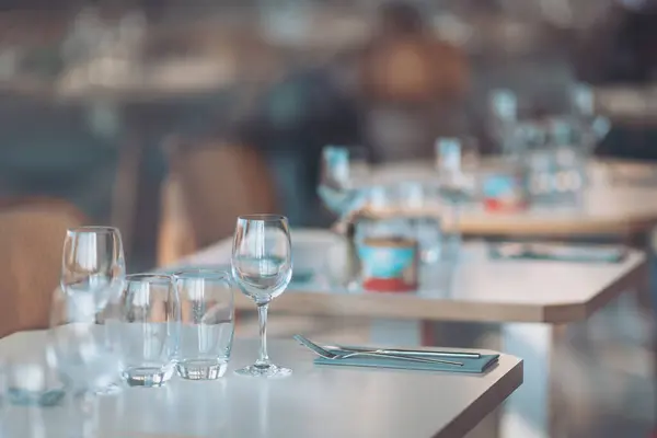 Günbatımında çağdaş bir restoranda güzel düzenlenmiş masalar ve konuklara özel köpüklü cam eşyalar ile şık bir akşam yemeği.