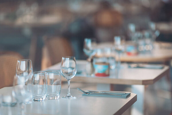 Elegant dining setting in a contemporary restaurant at sunset with beautifully arranged tables and sparkling glassware ready for guests