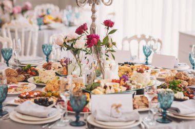 Bir dizi lezzetli yemek ve çiçekli süslemelerin yer aldığı unutulmaz bir kutlama için ihtişamlı bir ziyafet seti.