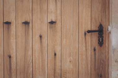 Güzel ahşap kapı, dekoratif sapı ve kırsal tarzında demir aksanı var.