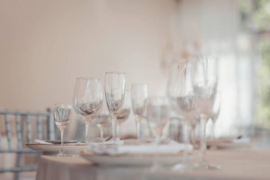 Öğleden sonra açık, havadar bir restoranda kristal cam eşyalar ve ince porselenlerle resmi bir yemek için şık bir sofra.