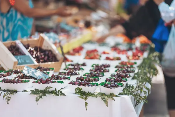 Canlı bir toplulukta canlı öğleden sonra saatlerinde taze üzümler ve çeşitli meyvelerin yer aldığı cömert bir piyasa gösterisi.