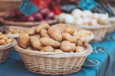 Sonbaharın güneşli bir gününde yerel bir markette hasat edilmiş patatesler hasat sepetinde sergileniyor.