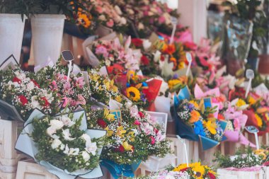Parlak bir öğleden sonra, hareketli bir pazarda sergilenen çiçek buketleri herkesi renkli cazibelerini ve güzel kokularını keşfetmeye davet ediyor.