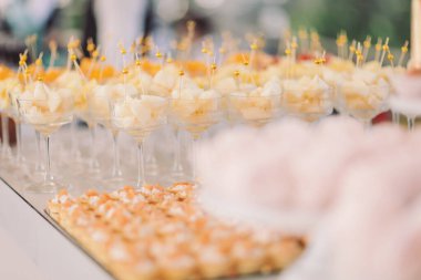 Delightful dessert table featuring creamy fruit cups and elegant pastries at a summer celebration in a sunny garden