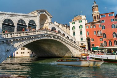 İtalya 'nın Venedik kentindeki ikonik Rialto Köprüsü' nde turistler, aşağıdaki Büyük Kanal 'da gezinen ve renkli tarihi binalarla çevrili manzaralara ve teknelere hayran kalıyorlar..