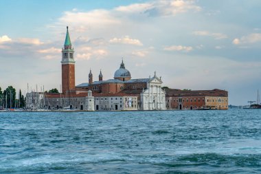 San Giorgio Maggiore Bazilikası ve İtalya 'nın Venedik kentindeki San Giorgio Maggiore Adası' ndaki çan kulesinin rıhtımına yanaşmış tekne ve yatlarla manzarası..