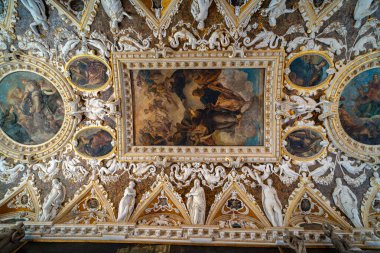 Tarihi bir sarayda mitolojik ve alegorik figürleri tasvir eden fresklerle, karmaşık altın detaylarıyla ve mermer heykellerle süslü ayrıntılı bir tavan..