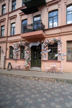 Pastel balonlar ve çiçeklerle süslenmiş, davetkar ve resimsel bir kafe..