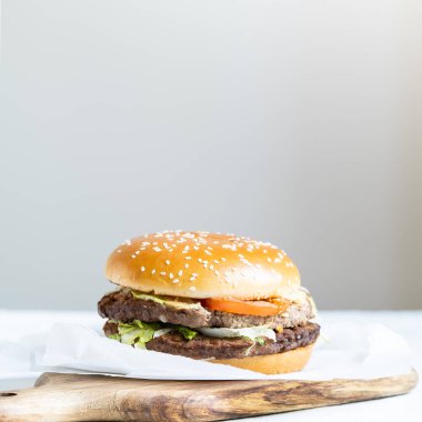 Dana pirzolası, domates, marul yaprağı ve salatalıklı duble çizburger. Fast food. Yüksek kalite fotoğraf