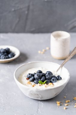 Fındık sütlü taze yulaf lapası fırında portakal, portakal reçeli ve gri arka planda fındık. Sağlıklı kahvaltı, sağlıklı yemek. Yüksek kalite fotoğraf